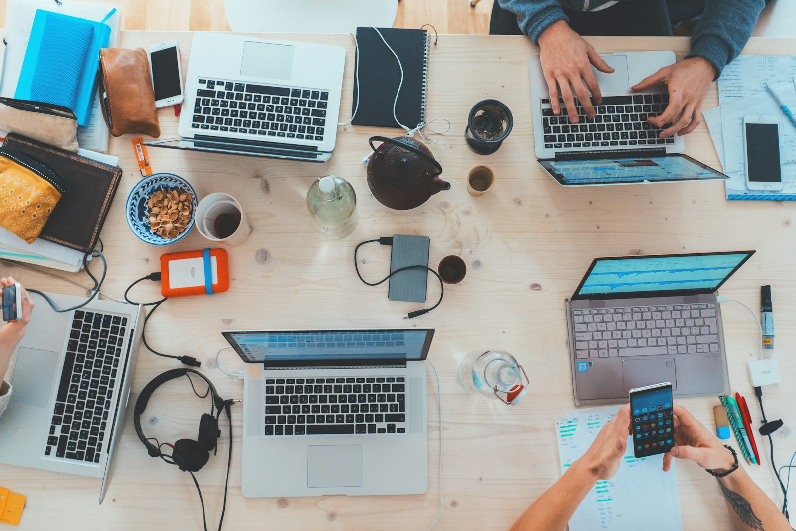 Marketing team collaborating around laptops at a shared table